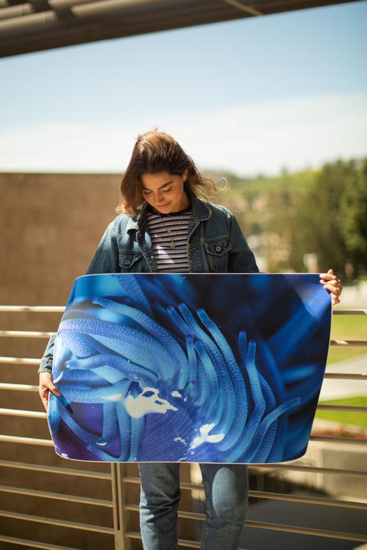 Isabella Jackson standing with one of her photographs